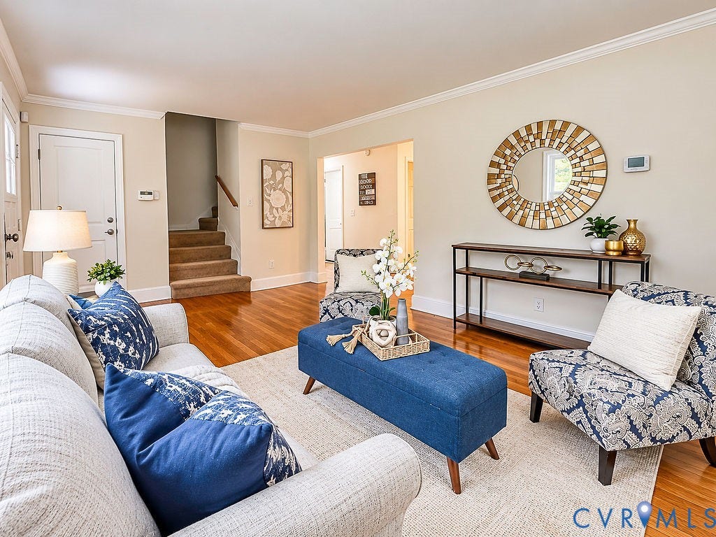 Hardwood flooring, crown molding, a console table, and staircase with carpeted treads