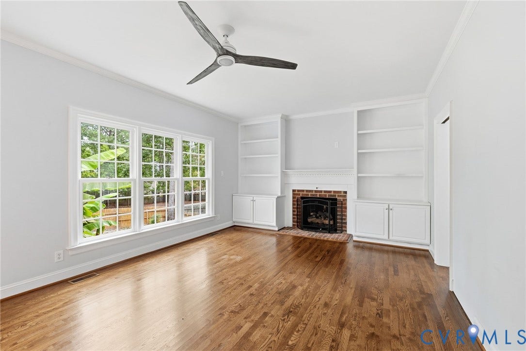 Living room with built-ins, fireplace and view of backyard