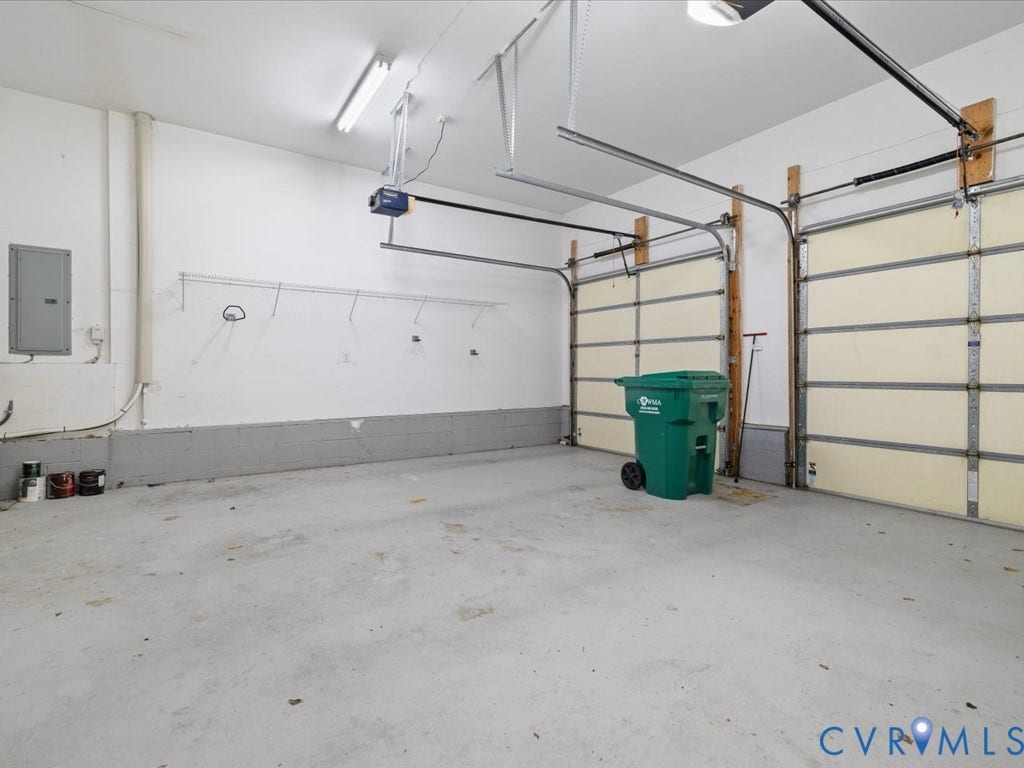 12126 Club Commons Drive, Club Commons, Glen Allen, VA 23059 Two garage bays featuring overhead doors and track systems, concrete flooring, and fluorescent lighting
