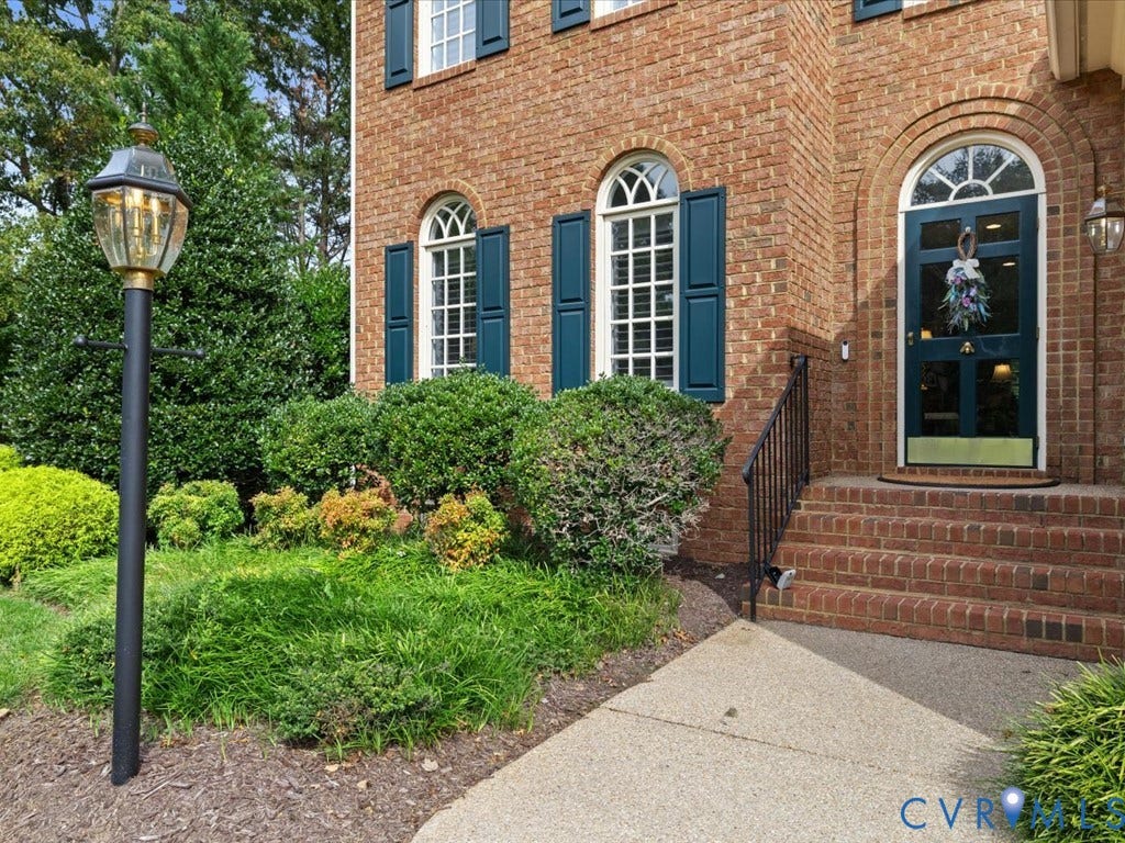 12126 Club Commons Drive, Club Commons, Glen Allen, VA 23059 Brick exterior with arched windows, decorative shutters, a prominent entry door, and a traditional lantern-style post light