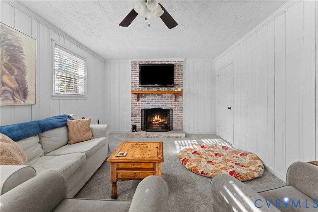 109 Webster Road, Sandston, VA 23150 Brick fireplace with a wood mantle, ceiling fan, and carpeted flooring
