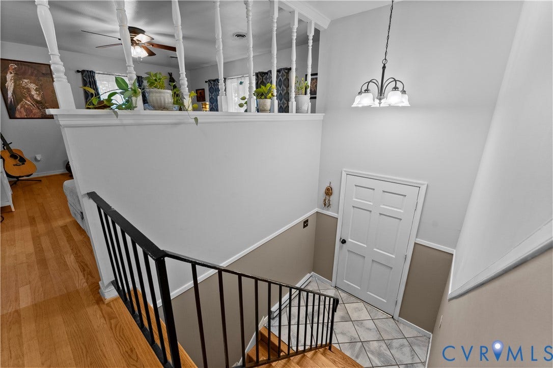 109 Webster Road, Sandston, VA 23150 Staircase featuring wood-finish treads, black metal railings, and a multi-paneled door