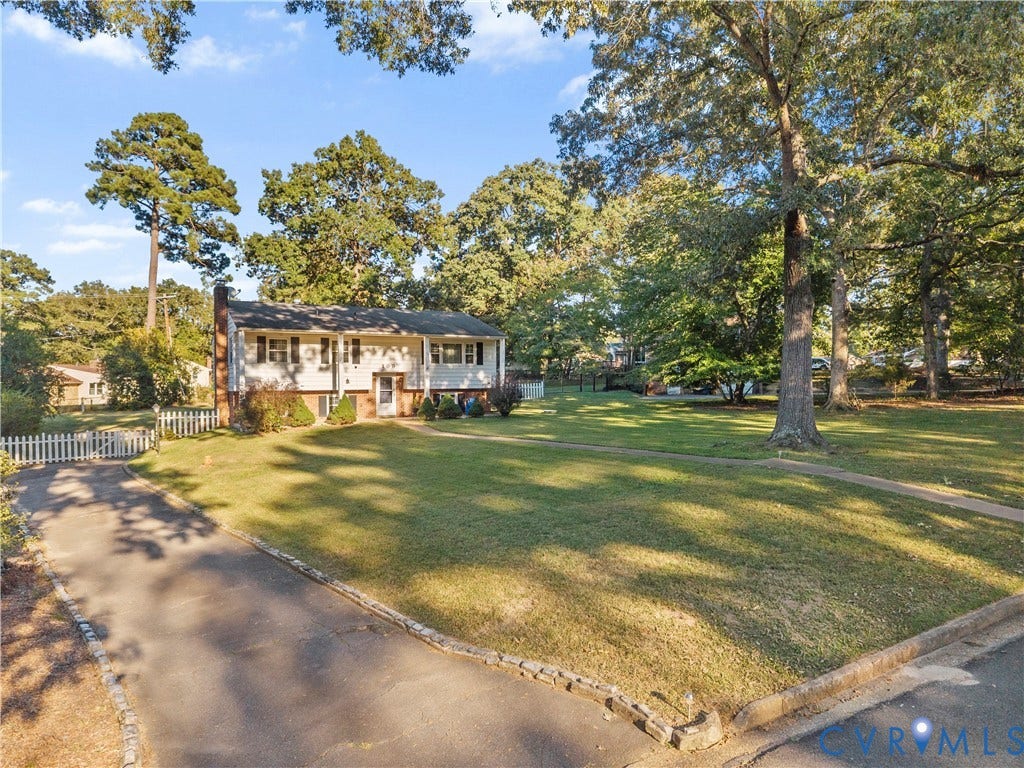 109 Webster Road, Sandston, VA 23150 Split-level residence with a side-gabled roof, white picket fencing, and a paved driveway