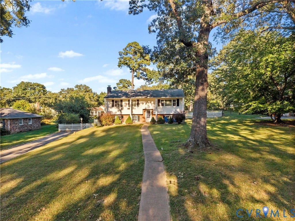 109 Webster Road, Sandston, VA 23150 Split-level residence featuring a white picket fence, mature trees, and a concrete walkway leading to the front entry