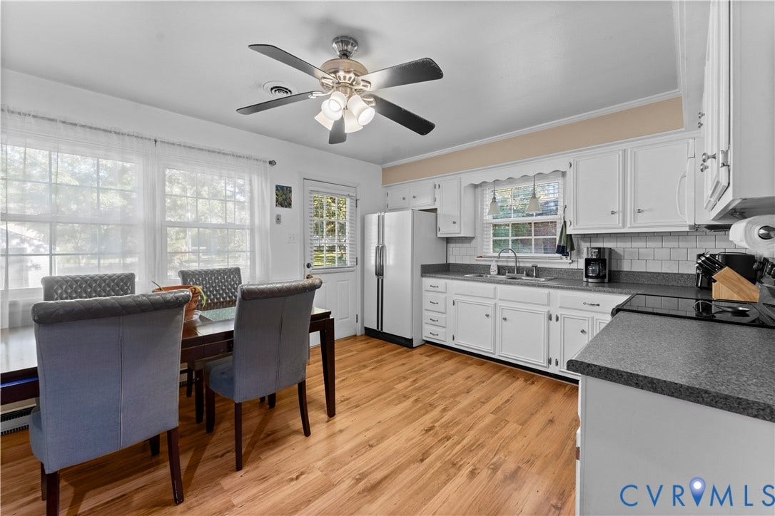 109 Webster Road, Sandston, VA 23150 Kitchen featuring wood-finish flooring, white cabinetry, dark countertops, and a white subway tile backsplash