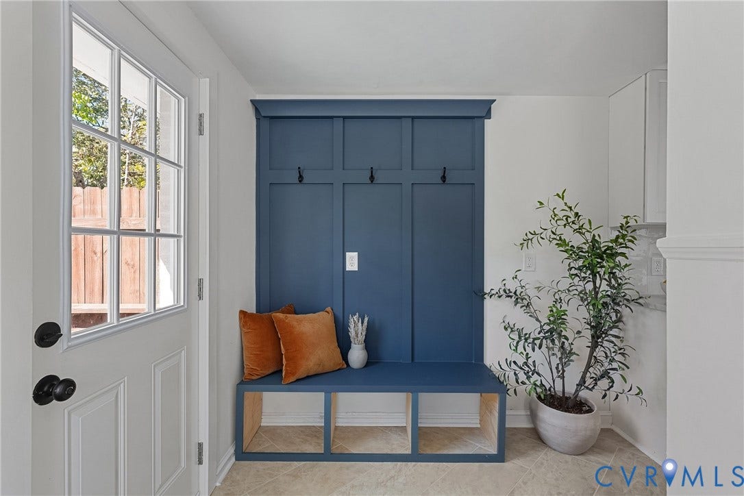 5304 Gillespie Avenue, Henrico, VA 23228 Entryway with a white paneled door featuring multiple glass lites, a built-in blue storage bench, and wall-mounted hooks