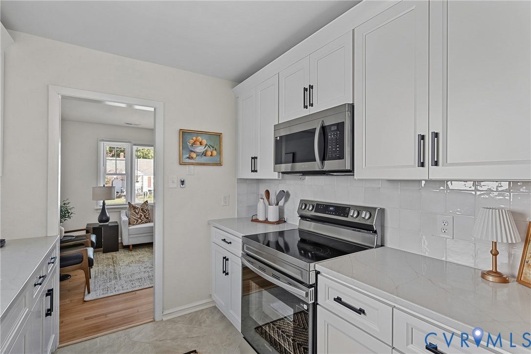 5304 Gillespie Avenue, Henrico, VA 23228 White shaker cabinetry with matte black hardware, stainless steel microwave, stainless steel range, white subway tile backsplash, and light-toned countertops