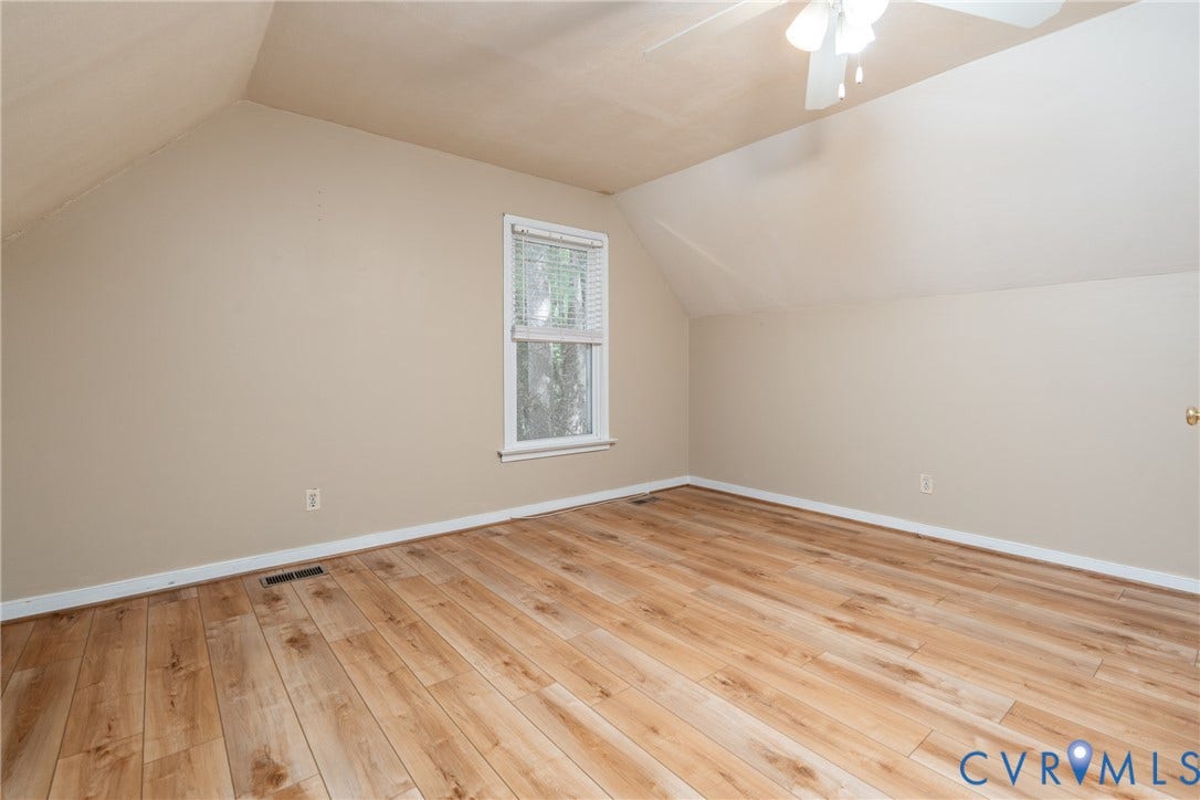Wood-finish flooring throughout, neutral wall paint, white window blinds, and white ceiling fan