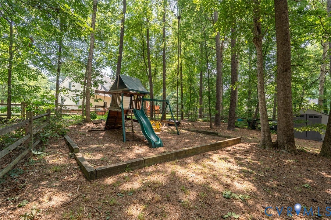 Expansive wooded property featuring mature trees and a fenced boundary