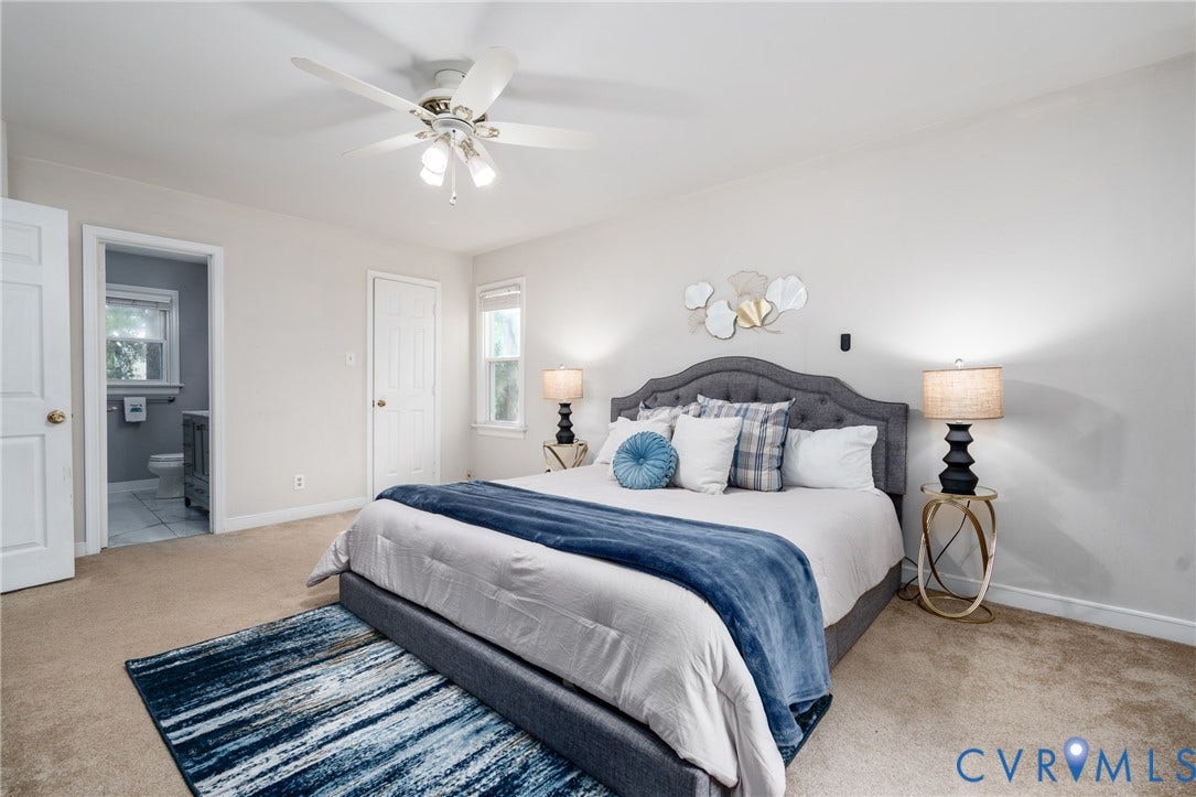 Carpeted flooring, ceiling fan with light fixture, and windows providing natural illumination