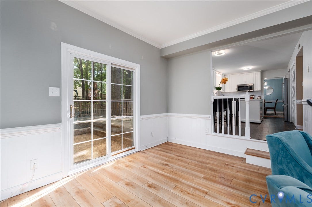 Wood-finish flooring, white wainscoting, and crown molding.