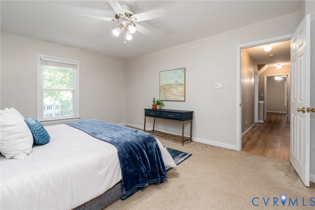 Recessed lighting, ceiling fan, natural light from a window, carpet flooring, and a hall with wood-finish flooring