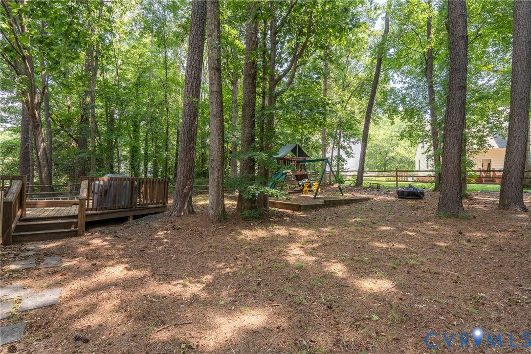 Wood deck with integrated steps, surrounded by mature trees.