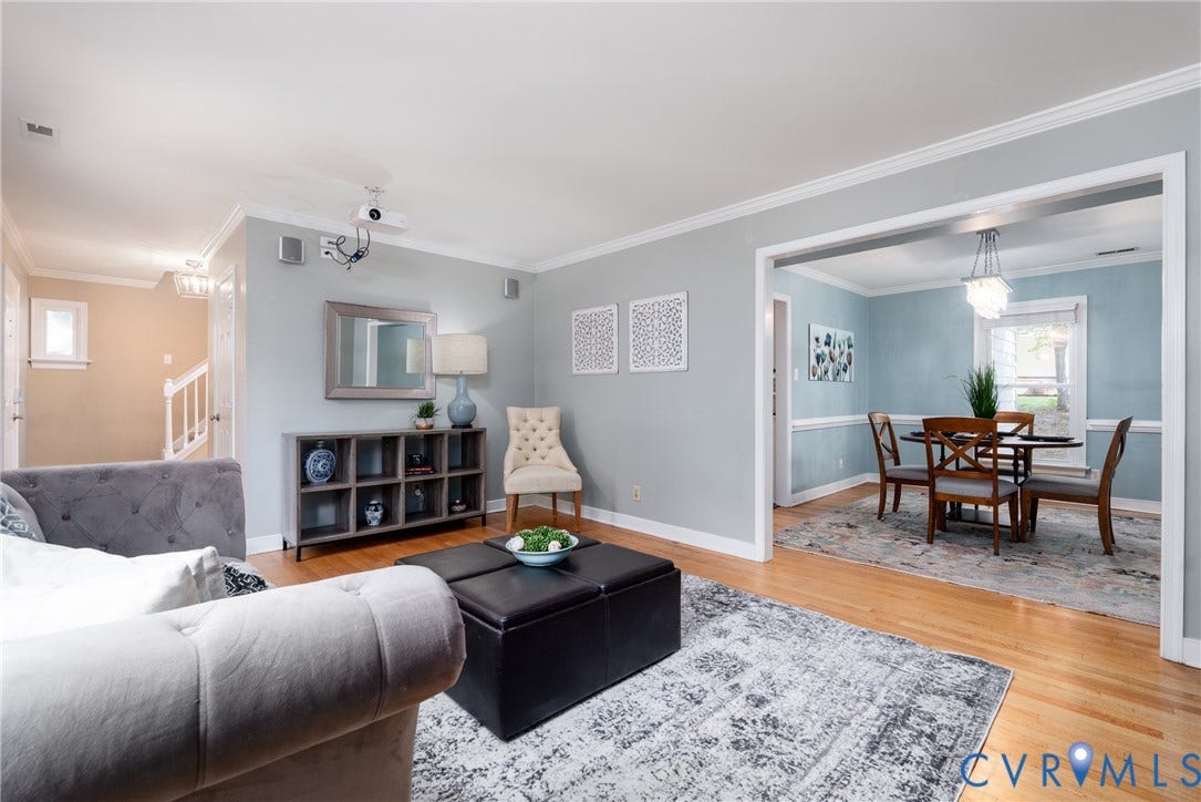 Hardwood flooring throughout, crown molding, cased entryways, built-in shelving, and a modern chandelier.