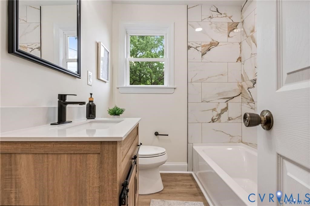 Wood-finish vanity with a white countertop and undermount sink