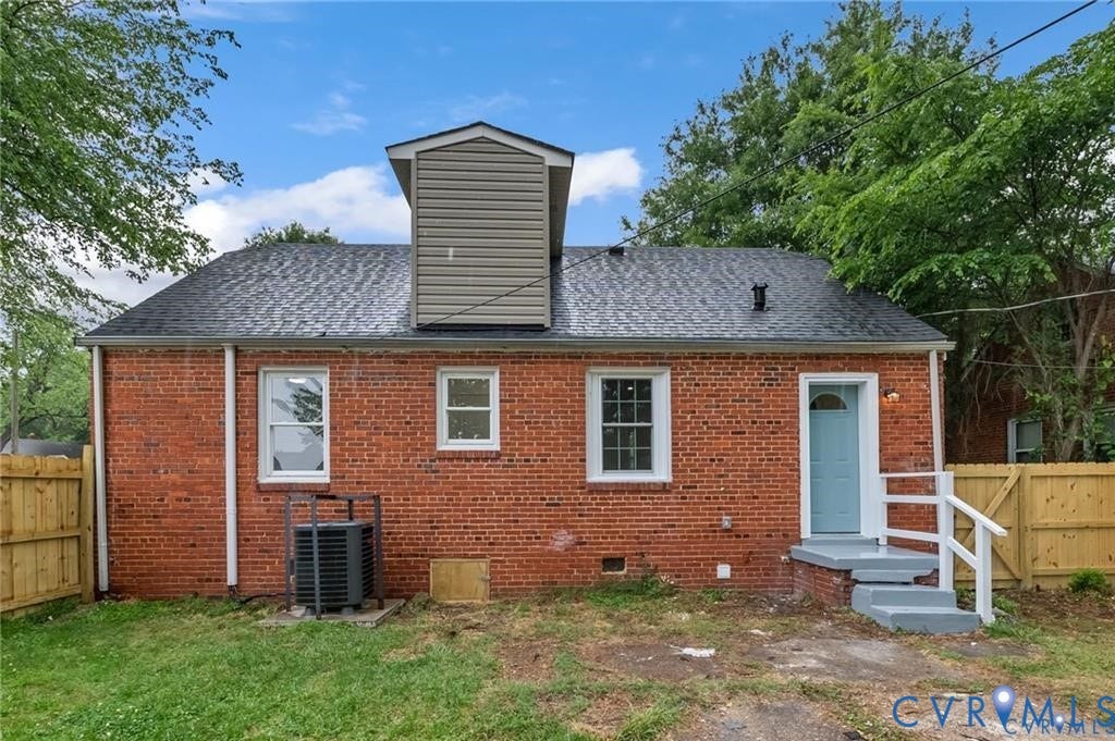 Red brick exterior with a gray shingle roof, complemented by a light blue entry door