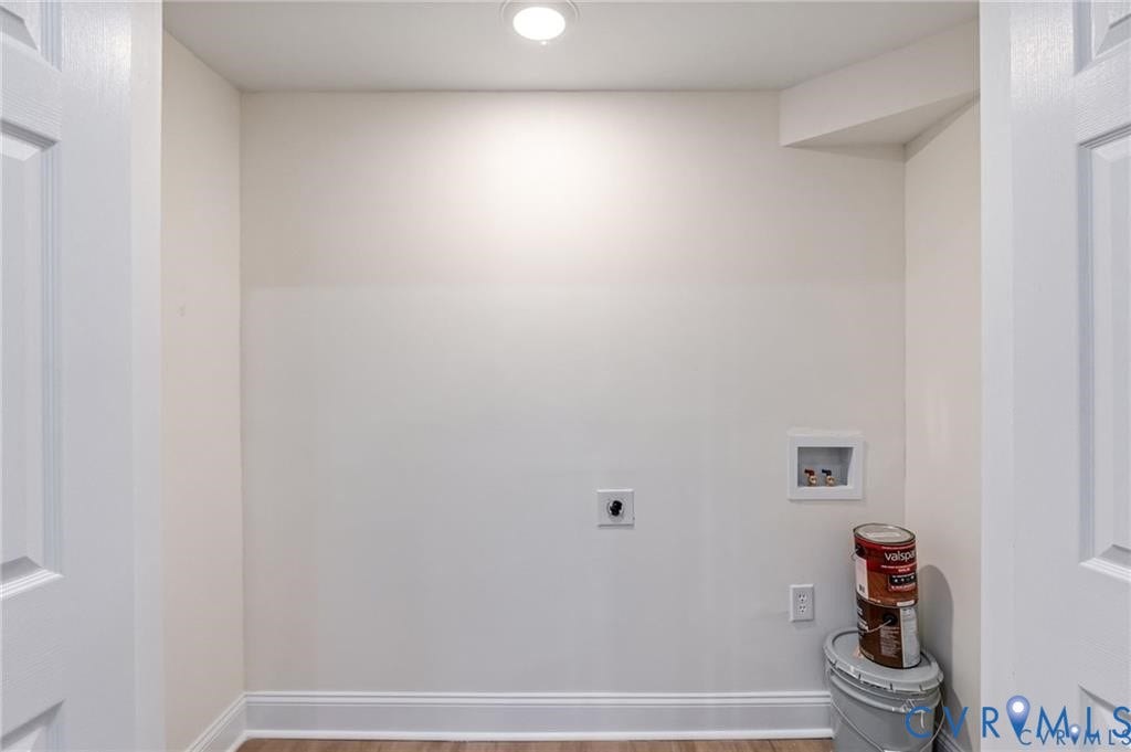 Recessed ceiling light, white walls, wood-finish flooring, two white paneled doors, utility hookups