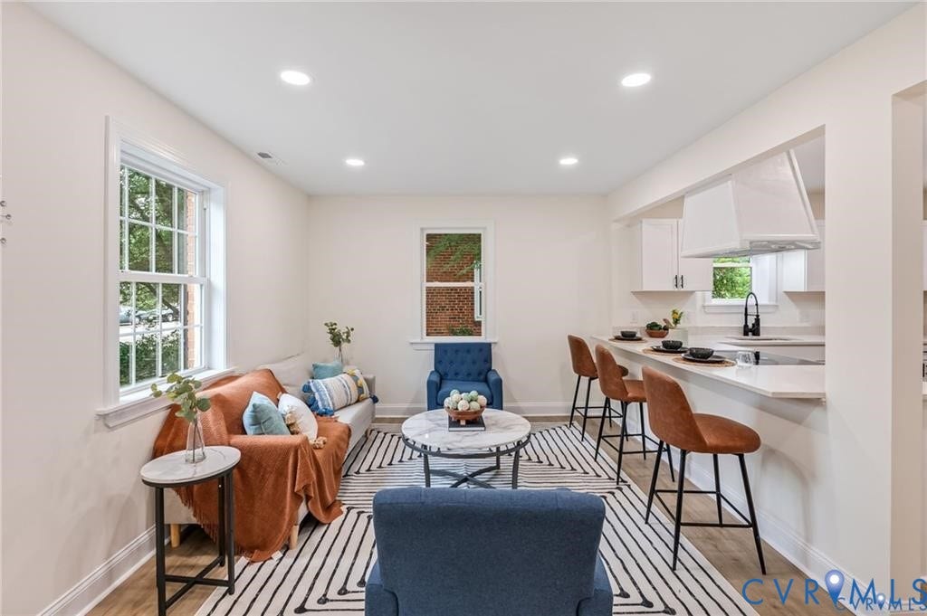 Open-concept living space featuring recessed lighting, wood-finish flooring, and white trim