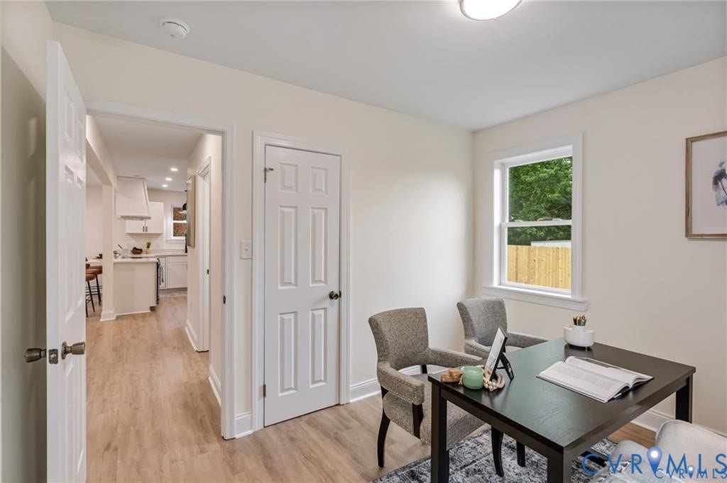 Wood-finish flooring throughout, white interior doors, and a window with white trim