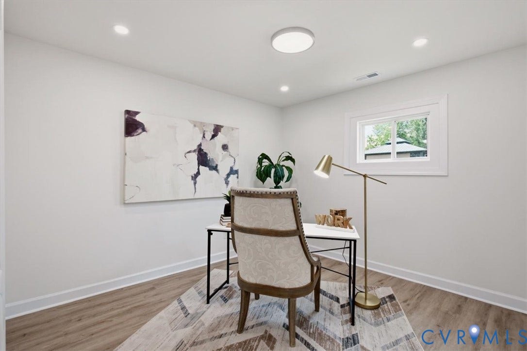 White walls with recessed lighting and a central flush-mount fixture, wood-finish flooring, and a white-framed window