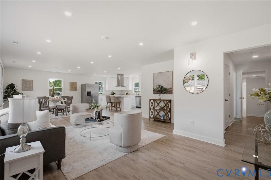 Open-concept living area featuring recessed lighting, wood-finish flooring, and a kitchen with a large island and stainless steel appliances
