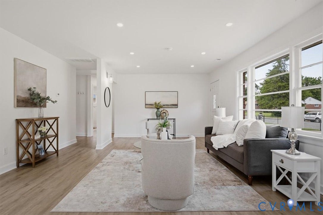 Living area with wood-finish flooring, recessed lighting, and expansive windows