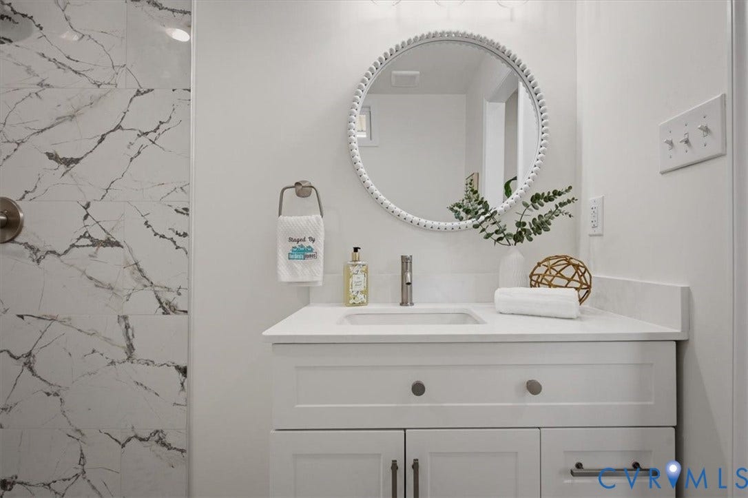 White vanity with shaker-style cabinetry, a white countertop, and an undermount sink