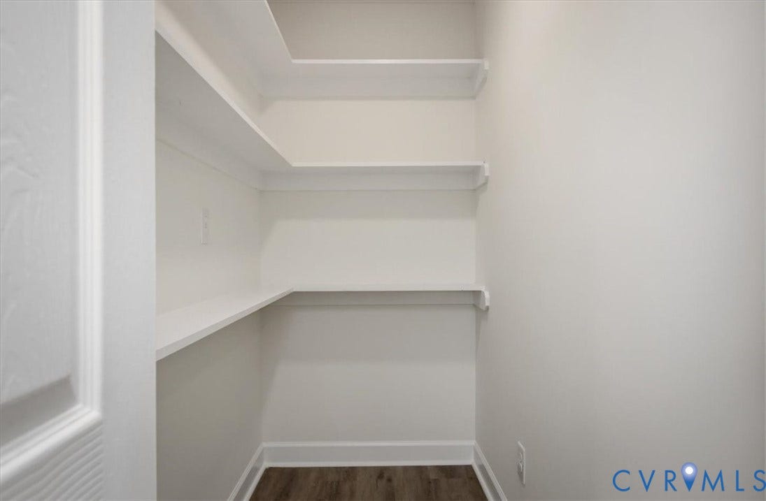 Built-in white shelving, wood-finish flooring, white wall paint, and white trim