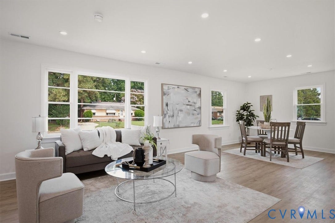 Recessed lighting, light wood-finish flooring, multiple large windows, and white painted walls