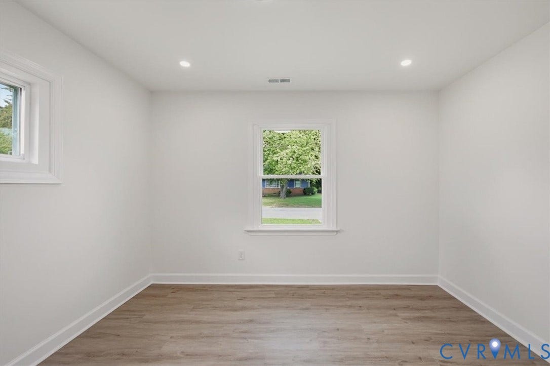 White walls, recessed lighting, wood-finish flooring, and white trim windows