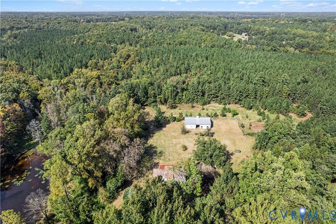 Extensive wooded acreage with a barn structure and a pond