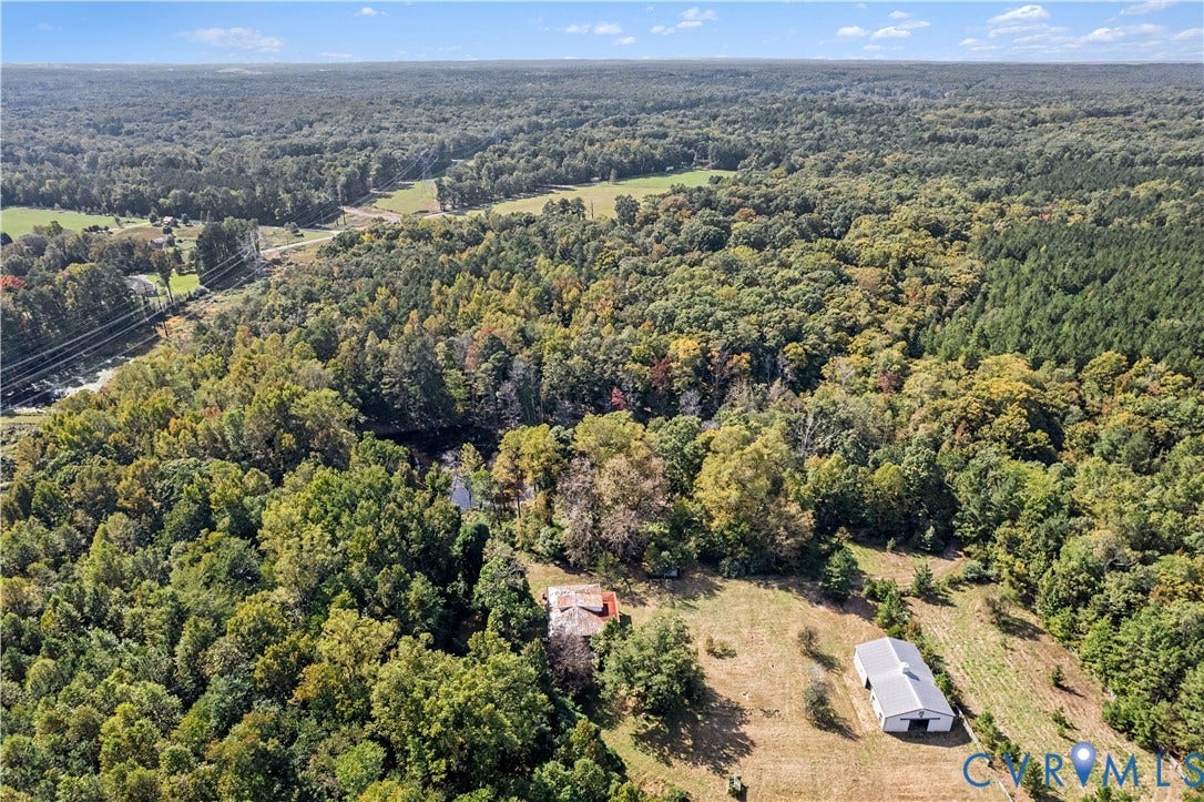 Expansive natural landscape featuring dense woodland and open fields