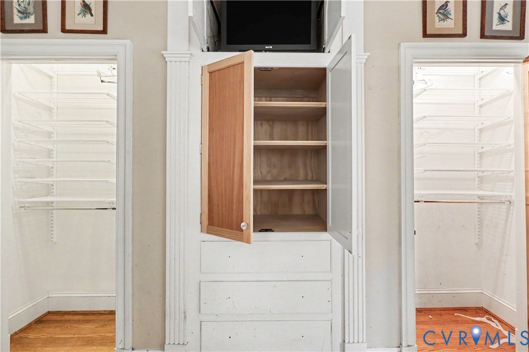 Built-in storage cabinetry with paneled doors and interior shelving, flanked by two closets featuring wire shelving systems