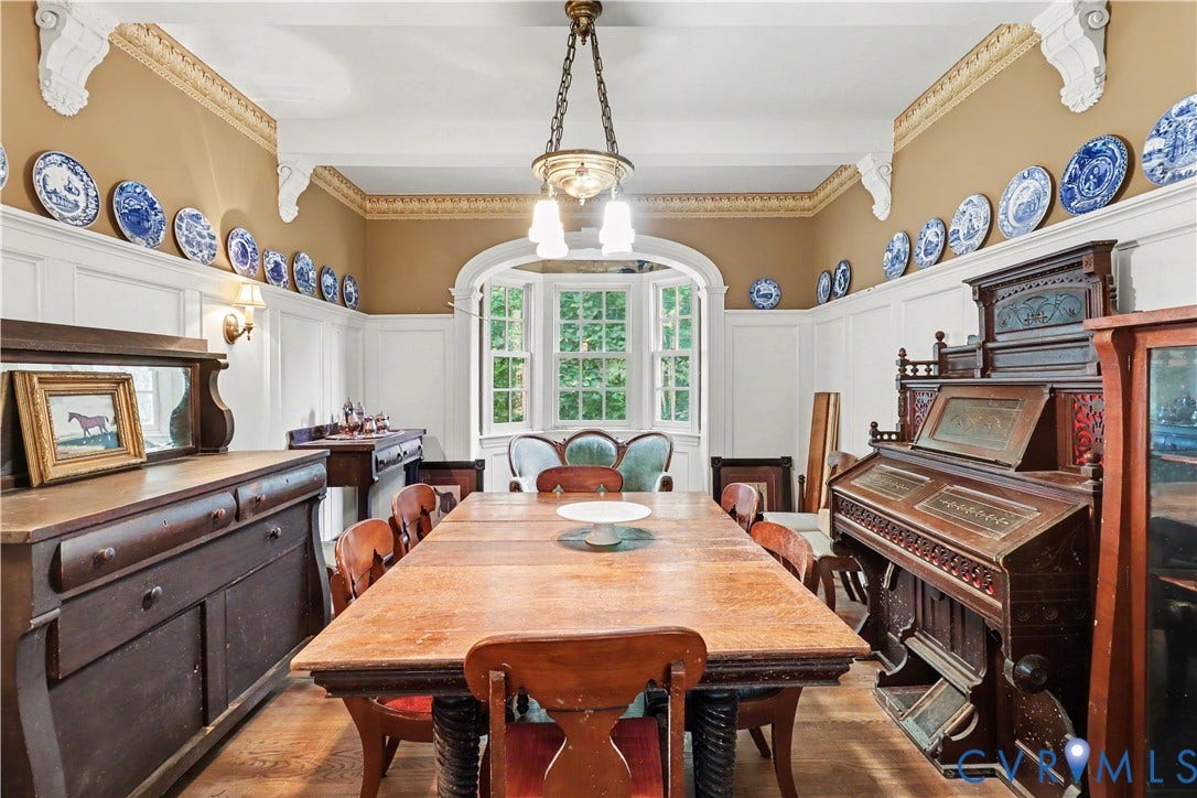 Bay window with multiple panes, decorative wainscoting, ornate wall sconces, wood flooring, and detailed ceiling trim