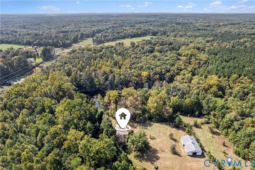 Expansive acreage featuring abundant mature trees and a prominent outbuilding