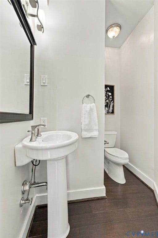 107 N Allen Avenue, The Fan, Richmond, VA 23220 Pedestal sink with a polished chrome faucet, framed wall mirror, dual-flush toilet, and wood-finish flooring