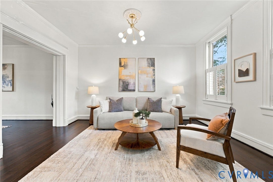 107 N Allen Avenue, The Fan, Richmond, VA 23220 Living area featuring dark wood-finish flooring, crown molding, a central multi-arm light fixture with a decorative ceiling medallion, and plantation shutters