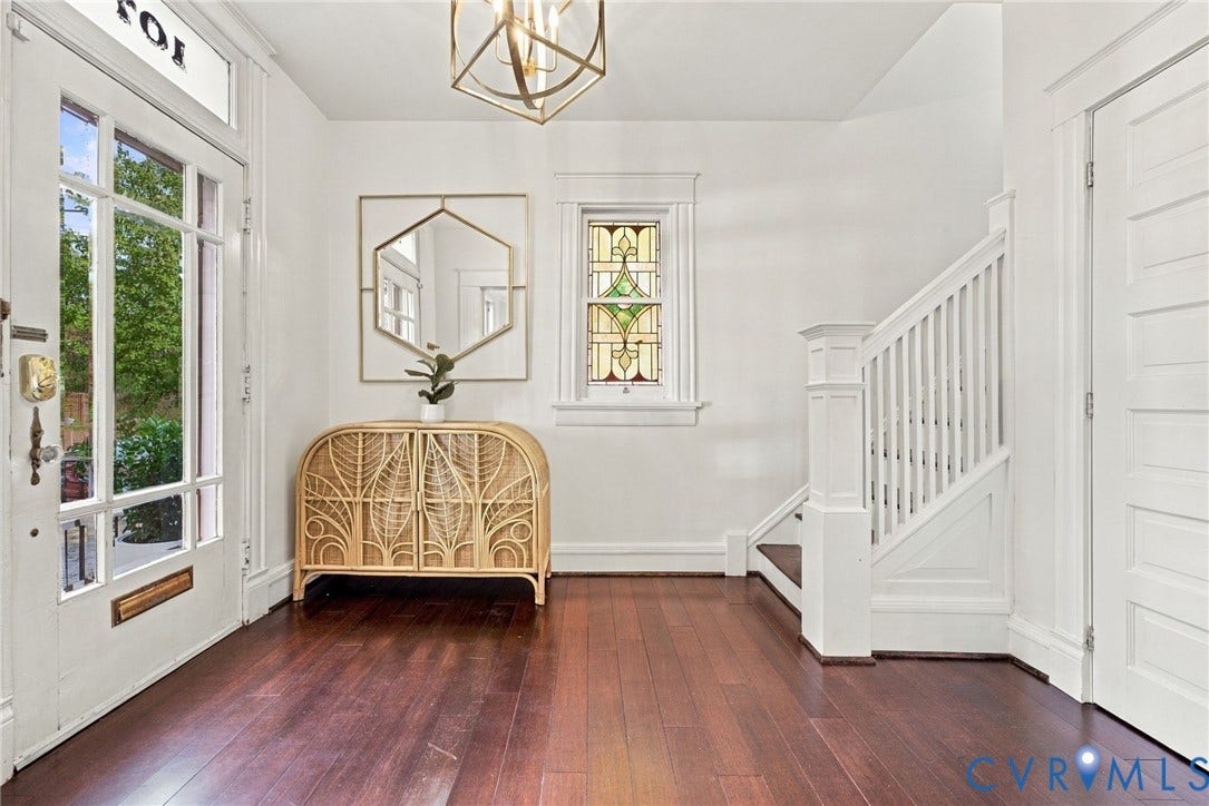 107 N Allen Avenue, The Fan, Richmond, VA 23220 Entryway featuring dark-stained wood-finish flooring, a multi-pane glass door with an integrated transom window, a stained glass window with decorative millwork, and a geometric metal pendant light fixture