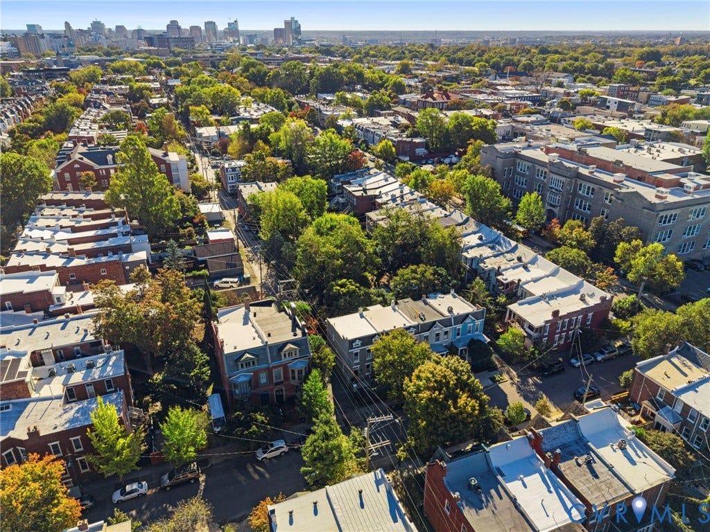 107 N Allen Avenue, The Fan, Richmond, VA 23220 Aerial perspective of urban neighborhood featuring dense tree canopy, brick masonry architecture, flat roofing systems, and city skyline backdrop