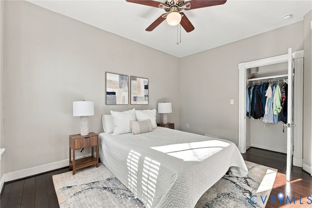 107 N Allen Avenue, The Fan, Richmond, VA 23220 Neutral-toned interior space featuring dark wood-finish flooring, a ceiling fan with light fixture, and a reach-in closet with integrated shelving