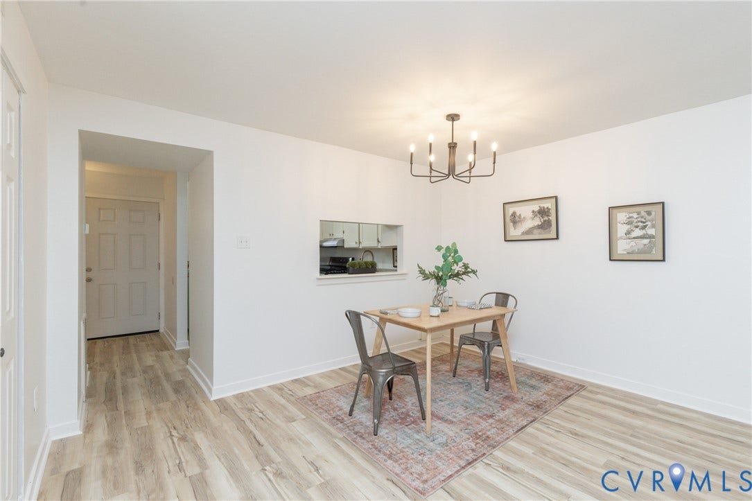 10404 Iron Mill Road, Chesterfield, VA 23235 Open-concept living space featuring wood-finish flooring, a contemporary chandelier, and a pass-through window.
