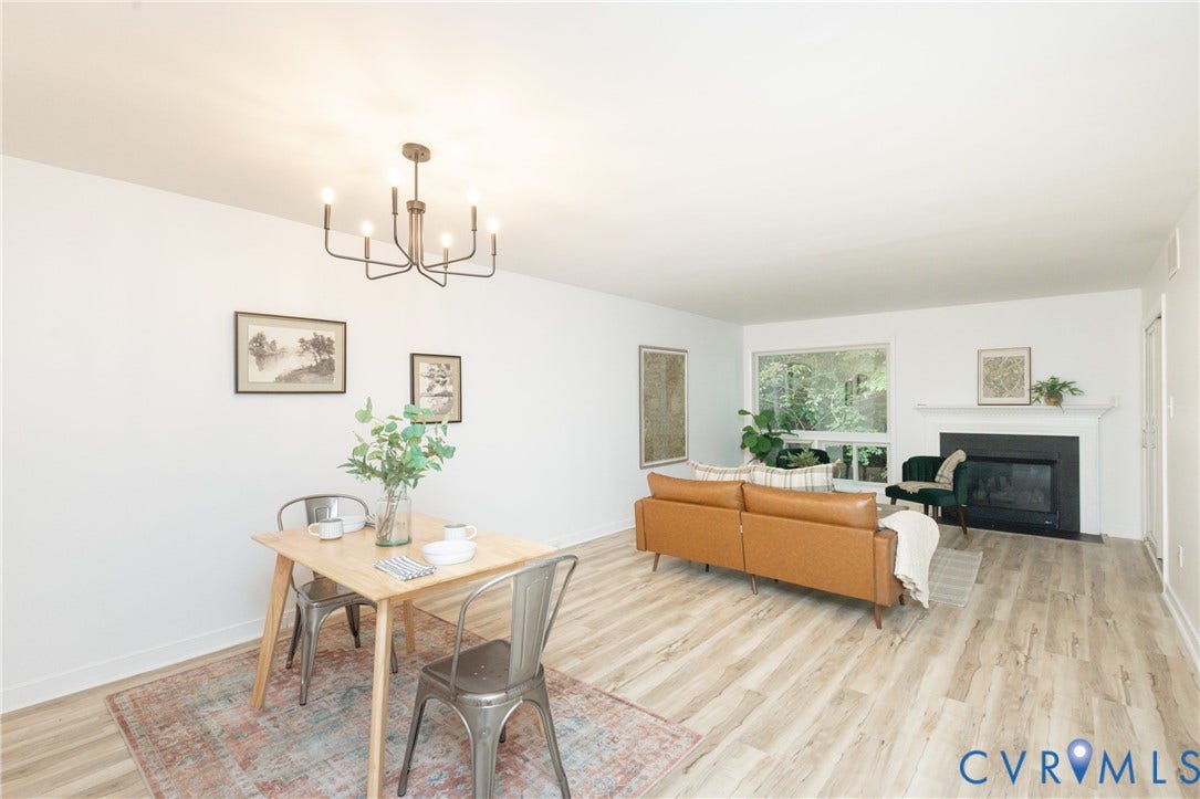 10404 Iron Mill Road, Chesterfield, VA 23235 Open-concept living area featuring wood-finish flooring, a contemporary chandelier, a built-in fireplace with a white mantel, and a large window