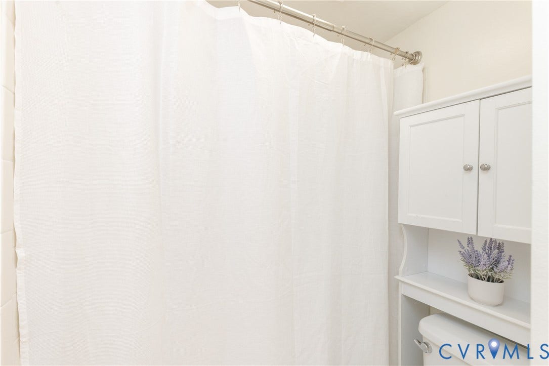10404 Iron Mill Road, Chesterfield, VA 23235 Shower and an over-the-toilet storage cabinet with white paneled doors