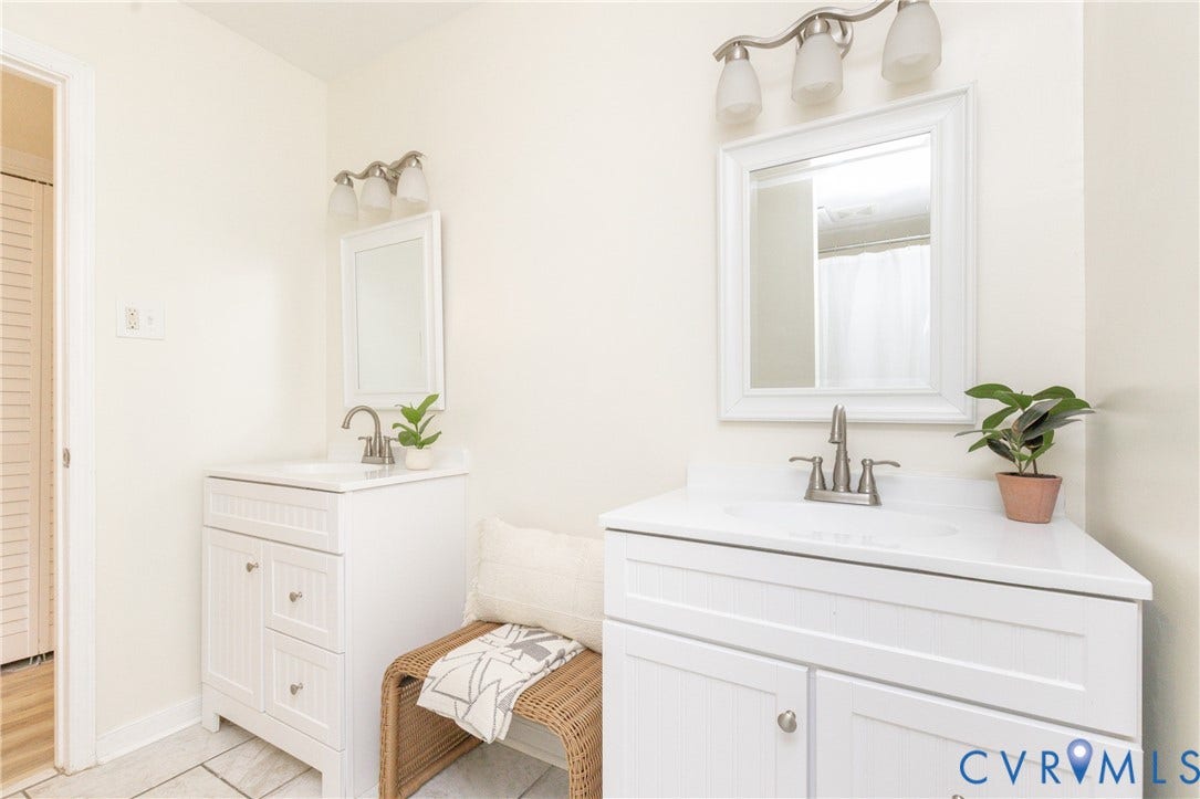 10404 Iron Mill Road, Chesterfield, VA 23235 Dual white vanities with integrated sinks, white framed mirrors, and brushed nickel fixtures
