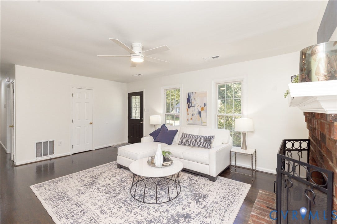 Dark wood-finish flooring, white walls, and a white ceiling fan with integrated lighting