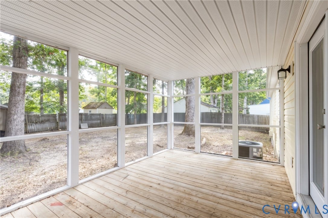 Screened porch featuring light wood-finish flooring, a beadboard ceiling, and direct backyard access
