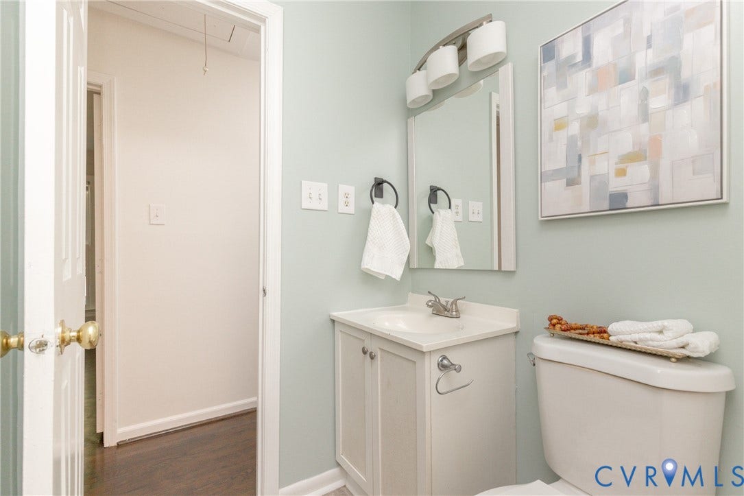 White vanity with an integrated sink, polished chrome faucet, and rectangular mirror