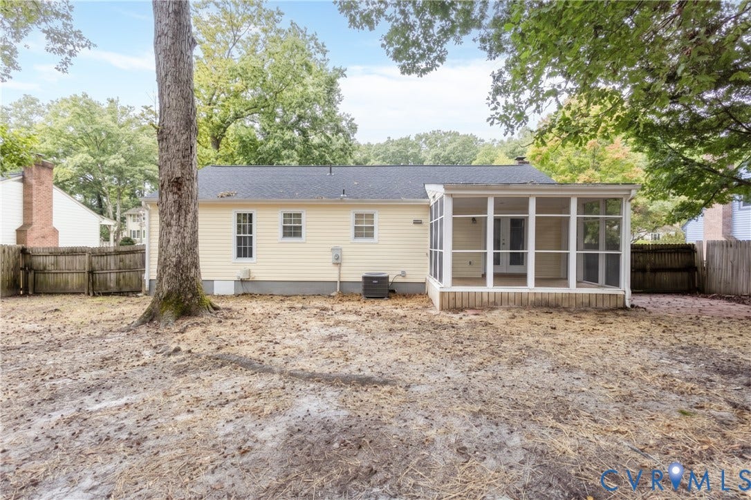 Rear exterior featuring a screened porch, wood siding, and a fenced perimeter