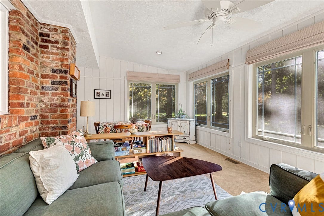 11410 Driscoll Road, Chester, VA 23831 Exposed brick chimney, board and batten wall paneling, large windows, and a ceiling fan