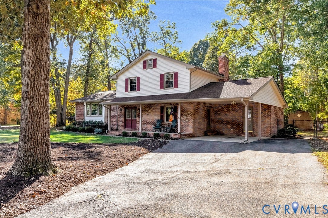 11410 Driscoll Road, Chester, VA 23831 Two-story residence featuring a partial brick and siding exterior, front covered porch, attached carport, and a paved driveway